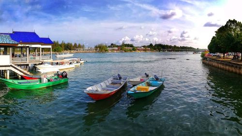 Boats moored in lake against sky