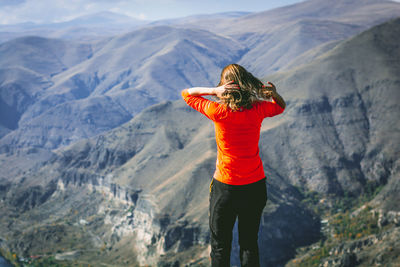 Rear view of woman standing against mountains