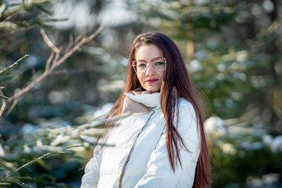 Portrait of a woman in white clothes in a cold winter forest