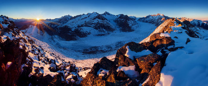 Panoramic view of snowcapped mountains against sky during sunset