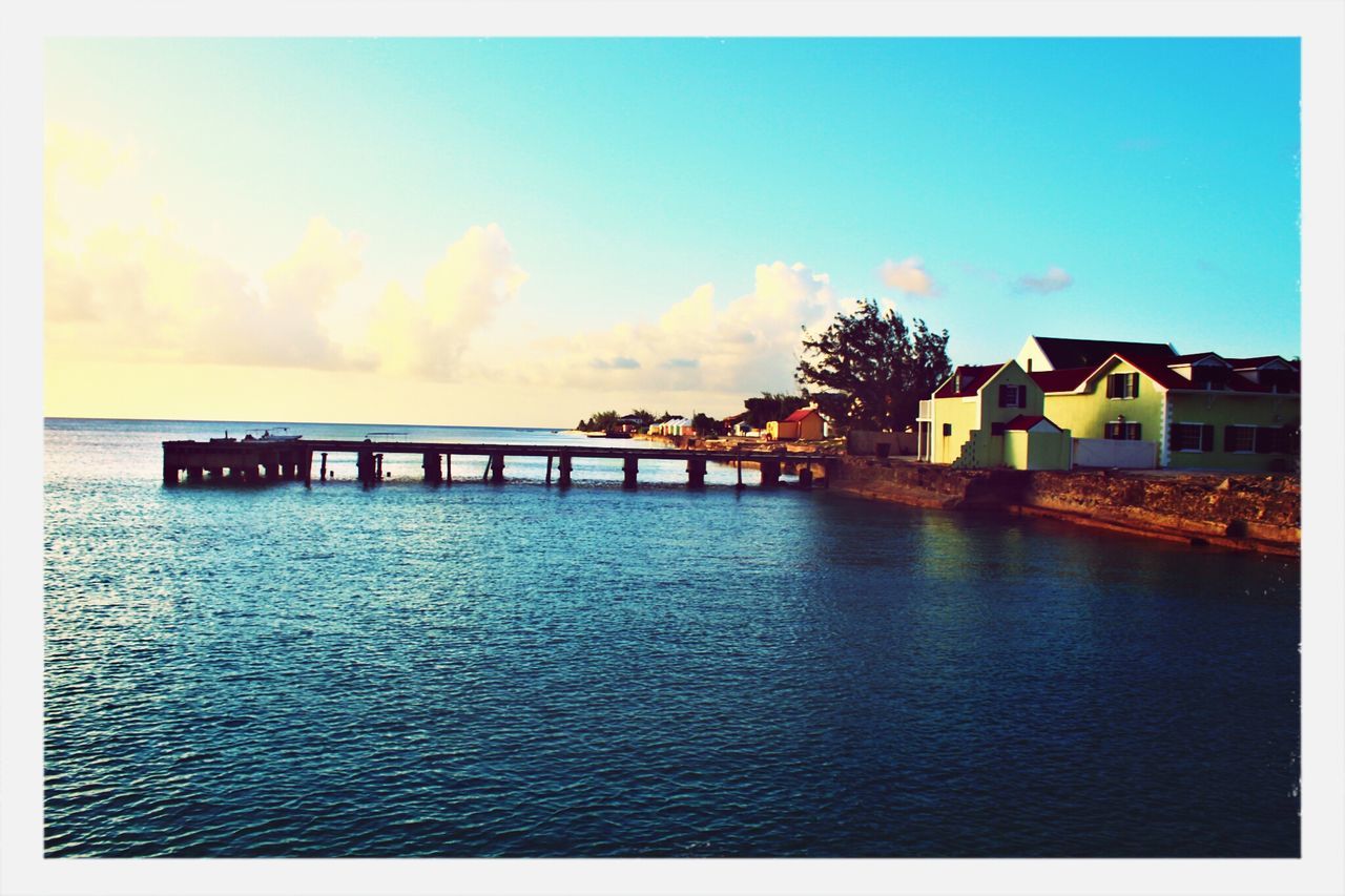 architecture, built structure, transfer print, water, building exterior, auto post production filter, sky, sunset, waterfront, sea, blue, dusk, cloud - sky, pier, nature, cloud, outdoors, reflection, scenics, beauty in nature