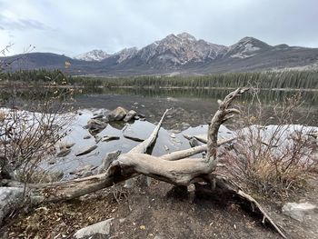 Scenic view of lake by mountains against sky