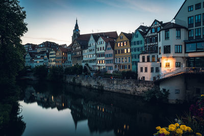 Reflection of buildings in city at dusk