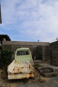 Abandoned car against sky