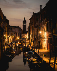 Boats moored in canal at night