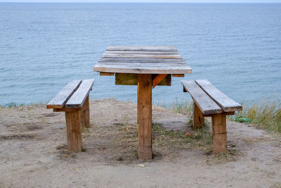 Bench on beach by sea