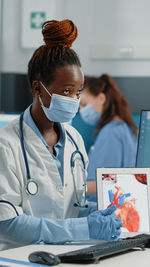 Doctor wearing mask showing medical tablet