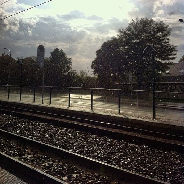 railroad track, rail transportation, transportation, public transportation, tree, railroad station platform, railroad station, railway track, train - vehicle, sky, train, mode of transport, travel, cloud - sky, passenger train, power line, day, public transport, no people, built structure