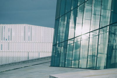 Modern building against sky seen through glass window