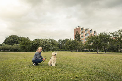 Mature woman spending leisure time with dog in park