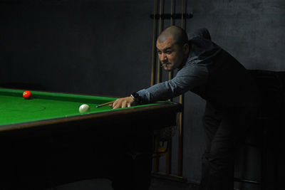 Young man playing billiards