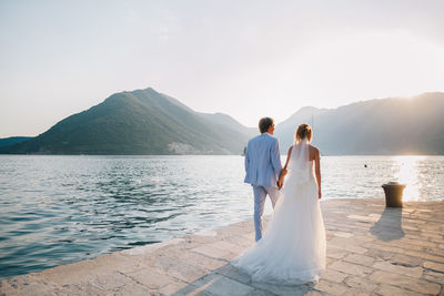 Rear view of couple holding hands