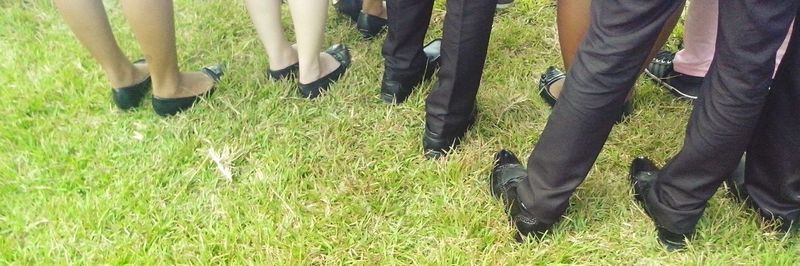 Low section of man standing on grassy field