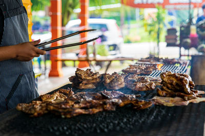 Ayam bakar or known as charcoal grilled chicken. roasted chicken in the smoky burning process.