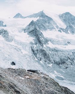 Scenic view of snowcapped mountains against cloudy sky