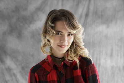 Young woman standing against backdrop