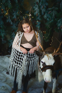 Portrait of young woman with horse on snow