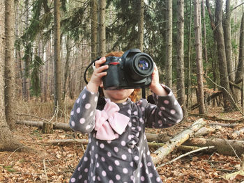 Girl photographing in forest