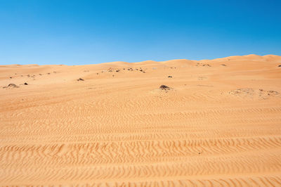 Scenic view of desert against clear blue sky