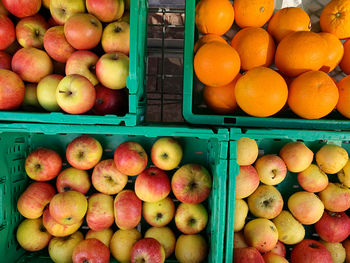 High angle view of apples and oranges for sale in weekly market