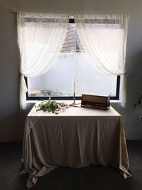 Radio with flowers and candle arranged on table against window