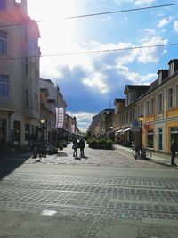 People on street in city against sky