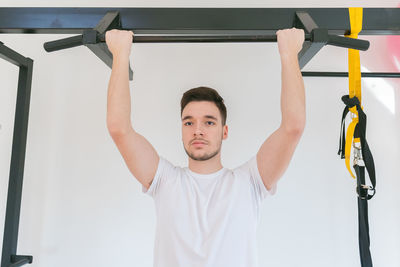 Young man at the gym isolated on white background