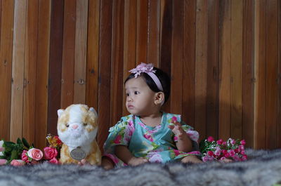 Cute girl looking away while sitting on toy