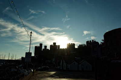 Street amidst buildings against sky during sunset