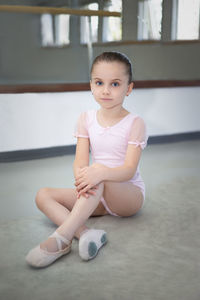 Portrait of cute boy sitting on floor at home