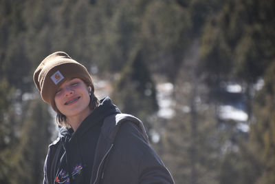 Portrait of teen boy standing in forest