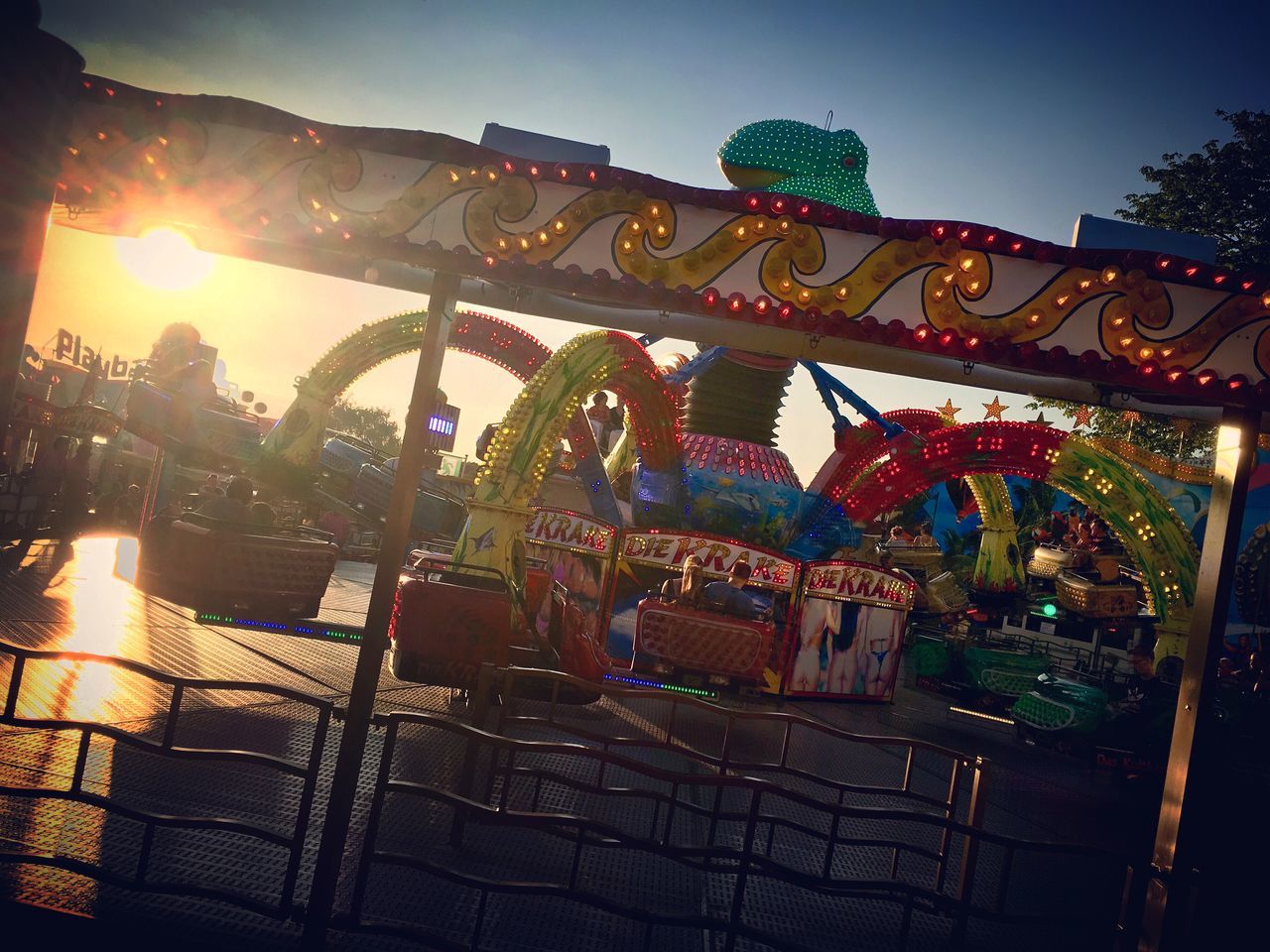 amusement park, amusement park ride, sky, multi colored, carousel, no people, arts culture and entertainment, architecture, illuminated, built structure, animal representation, representation, low angle view, nature, outdoors, lighting equipment, art and craft, creativity, building exterior, night, lens flare