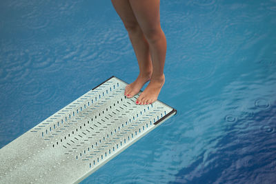 Low section of woman jumping diving board