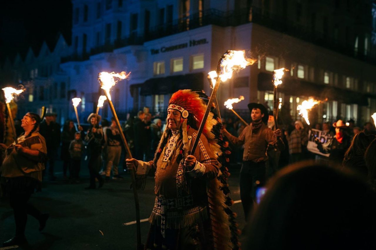 illuminated, night, building exterior, large group of people, men, lifestyles, street, built structure, architecture, person, leisure activity, celebration, city, crowd, lighting equipment, city life, light - natural phenomenon, arts culture and entertainment, event