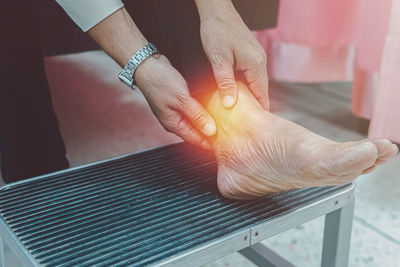 Close up older woman suffering from ankle pain, health problem and people concept