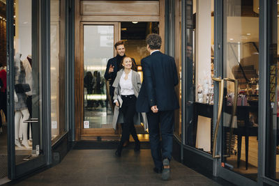 Smiling businesswoman with male colleague walking in alley