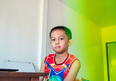 Portrait of boy against wall at home