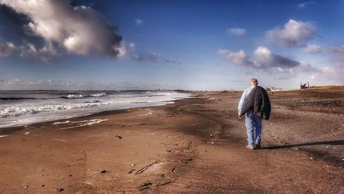 Rear view of a man walking on beach