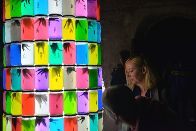 Full length portrait of woman standing against multi colored background