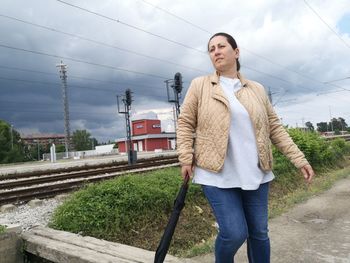 Full length of man standing on railroad tracks against sky