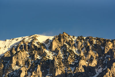 Scenic view of snowcapped mountains against clear blue sky