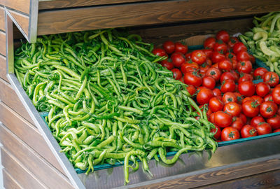 Green chili peppers and tomatoes for sale at market