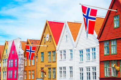 Low angle view of flags hanging against buildings in city