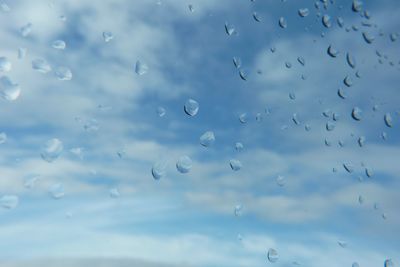 Low angle view of raindrops on window