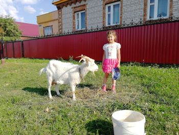Full length of a girl standing by plants on street