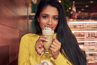 Portrait of woman holding dessert at restaurant