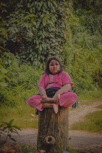 Portrait of a smiling girl standing against trees