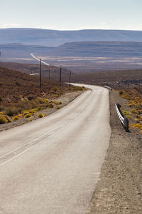 Road leading towards mountain against sky