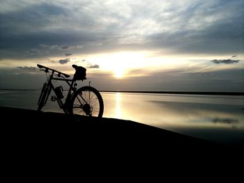 Scenic view of sea and bike at sunset