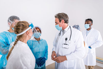 Doctors wearing mask standing against white background